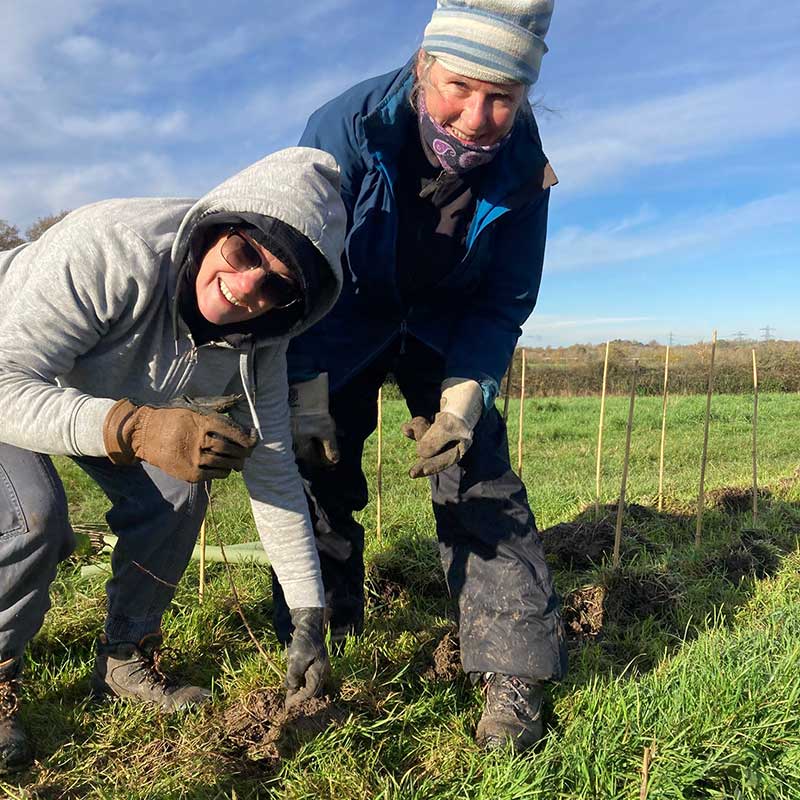 Two Lower Mole volunteers planting hedge